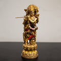 A sculpture of Radha and Krishna, with gold and multicolored accents, playing musical instruments.