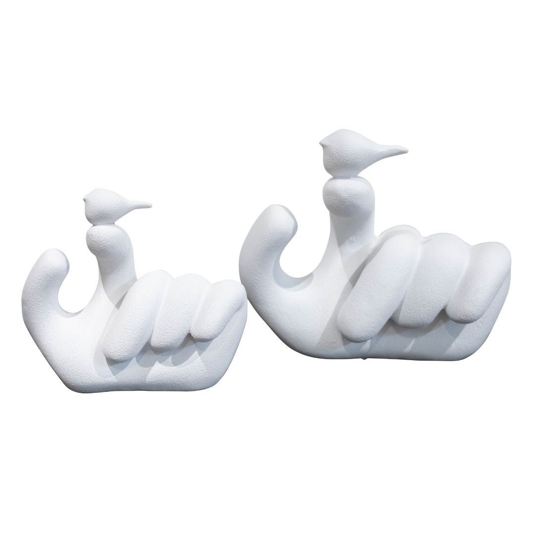 A white decorative sculpture depicting a man's figure with a bird perched on his hand