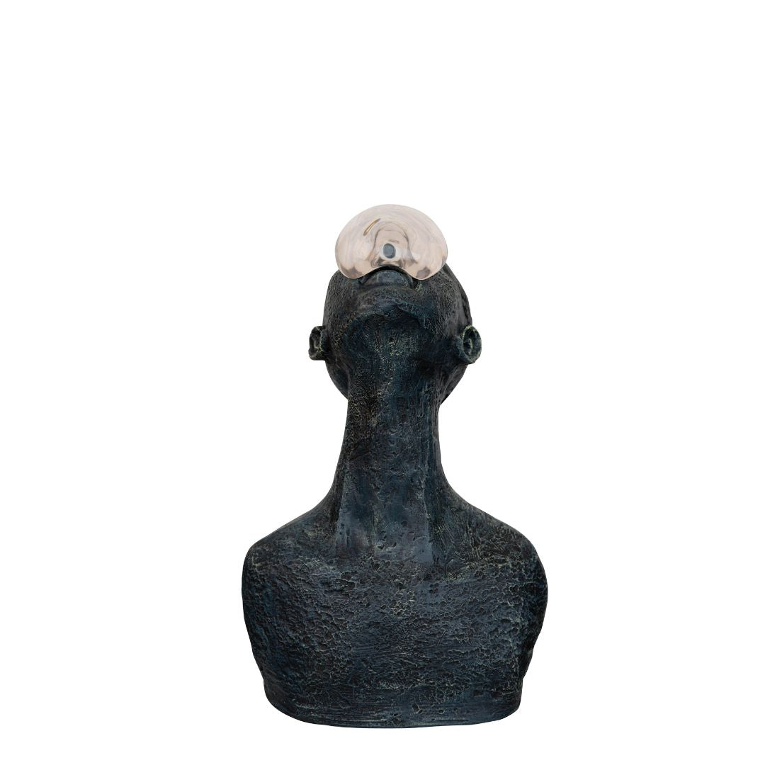 An abstract tabletop sculpture of a figure, topped with a globe like structure