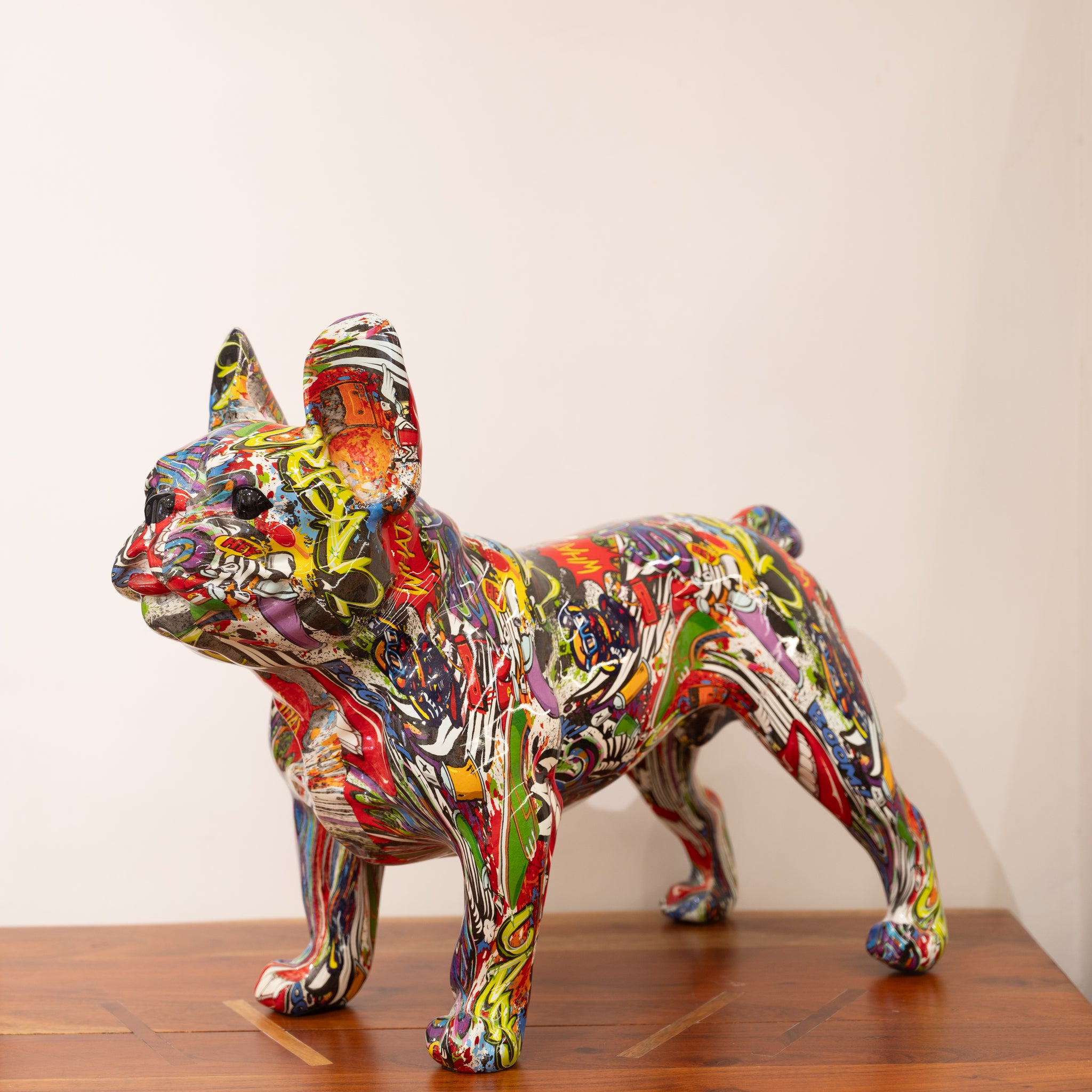 A multicolored, graffiti-style ceramic dog sculpture.