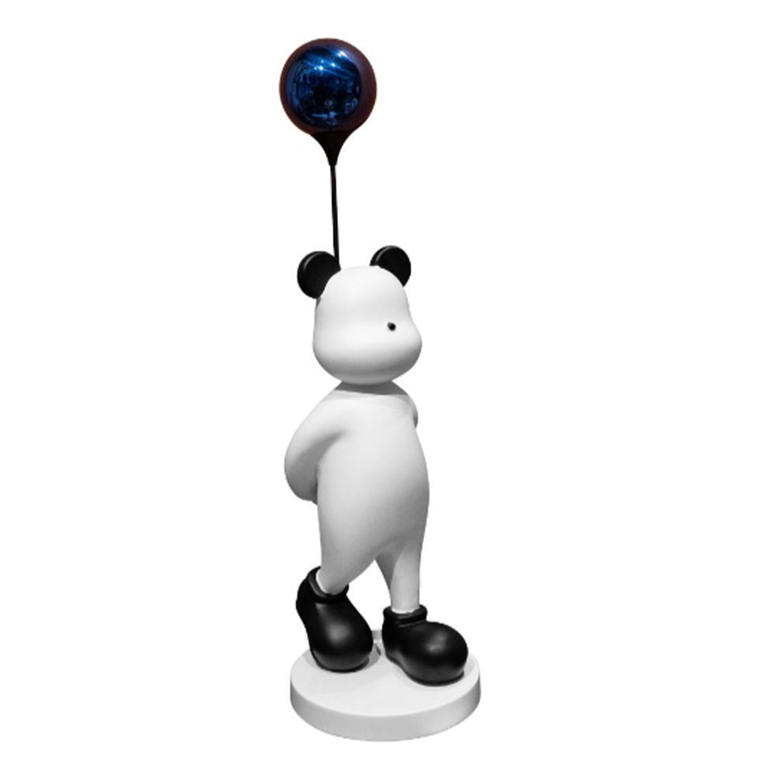A sculpture of a white bear with a blue balloon attached to its head.