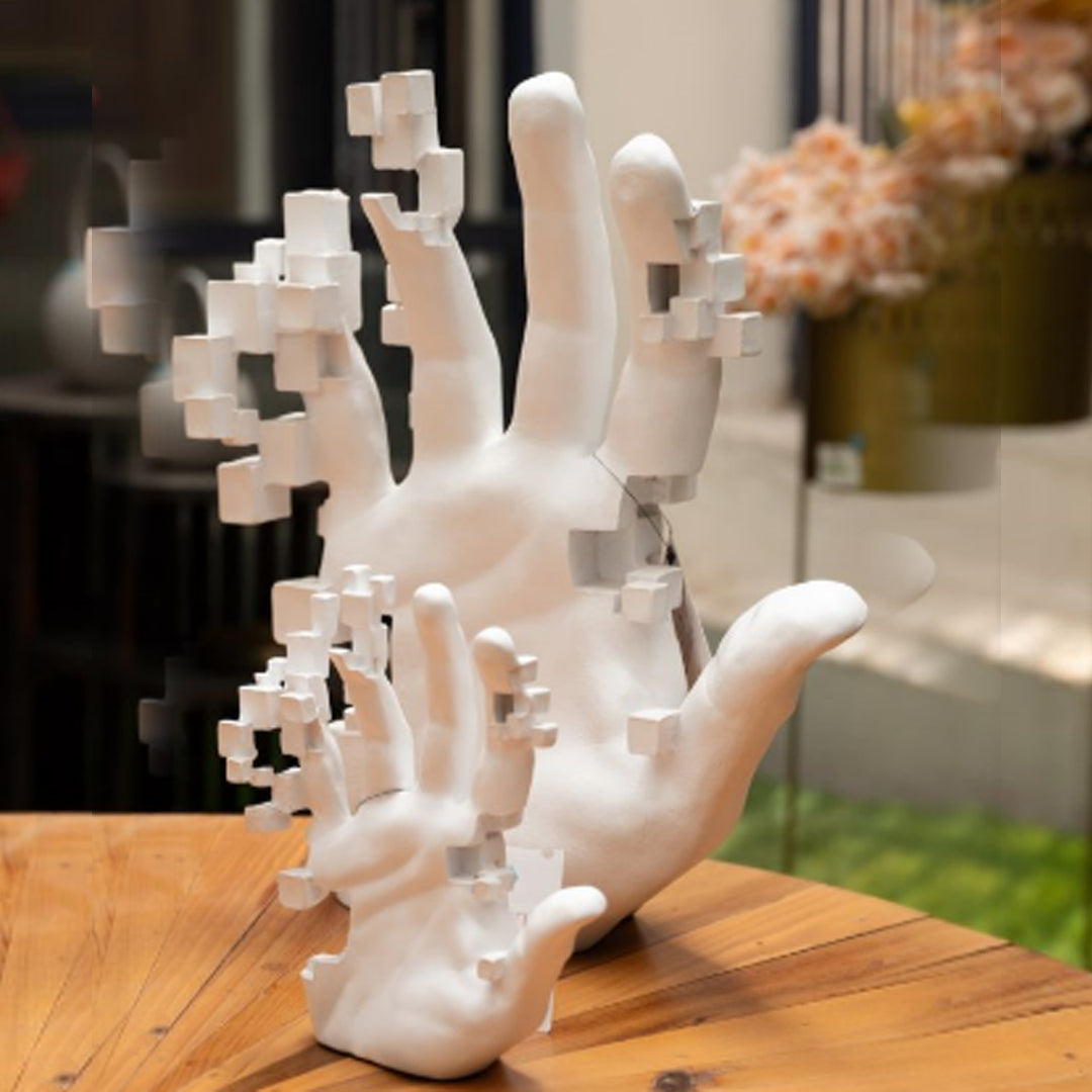 A white sculpture of a hand with fingers abstracted into geometric cubes.