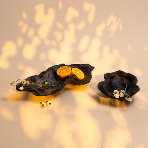 Two black ceramic bowls on a light background