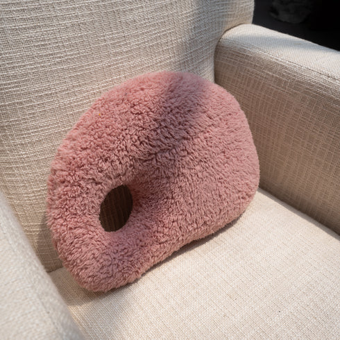 A pink, organic-shaped cushion 