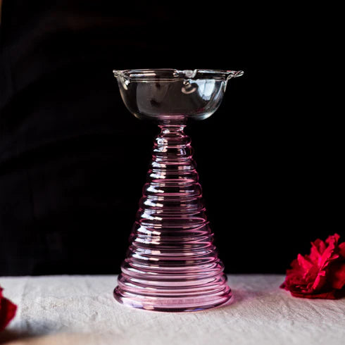 A tall glass Diya with a ribbed design