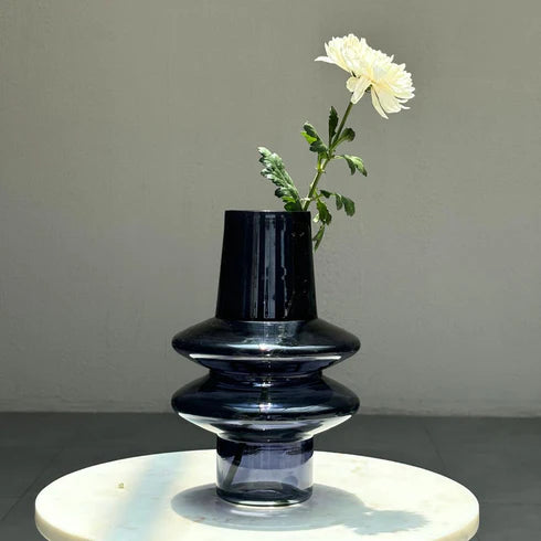 A slate grey glass vase with a playful ripple design